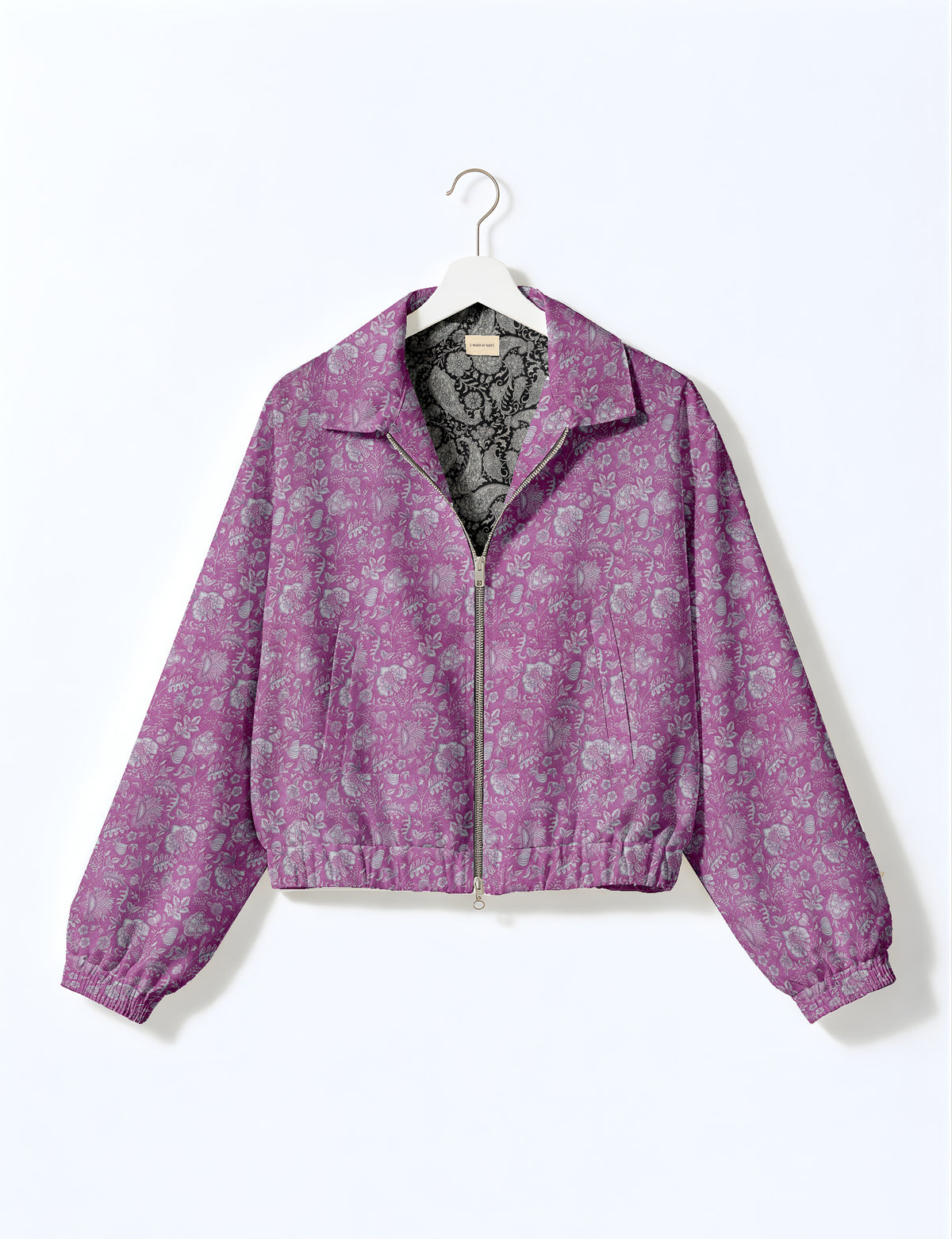 Woman wearing a yellow floral bomber jacket with front zipper, elastic cuffs, and side pockets, shown from front view