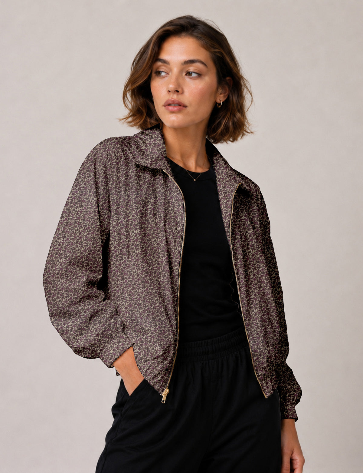 Brown floral bomber jacket with front zipper, elastic cuffs and hem, hanging on white hanger, red floral inner lining visible