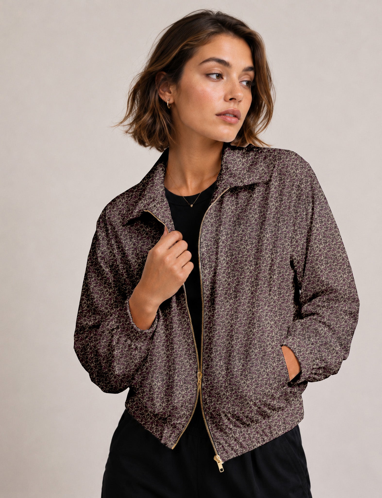 Woman wearing a yellow floral bomber jacket with front zipper, elastic cuffs, and side pockets, shown from front view