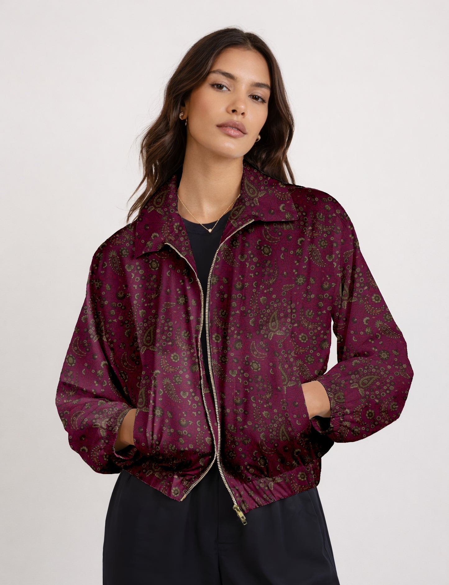 Woman wearing a yellow bomber jacket with a micro geometric pattern, front zipper, and side pockets, paired with black pants