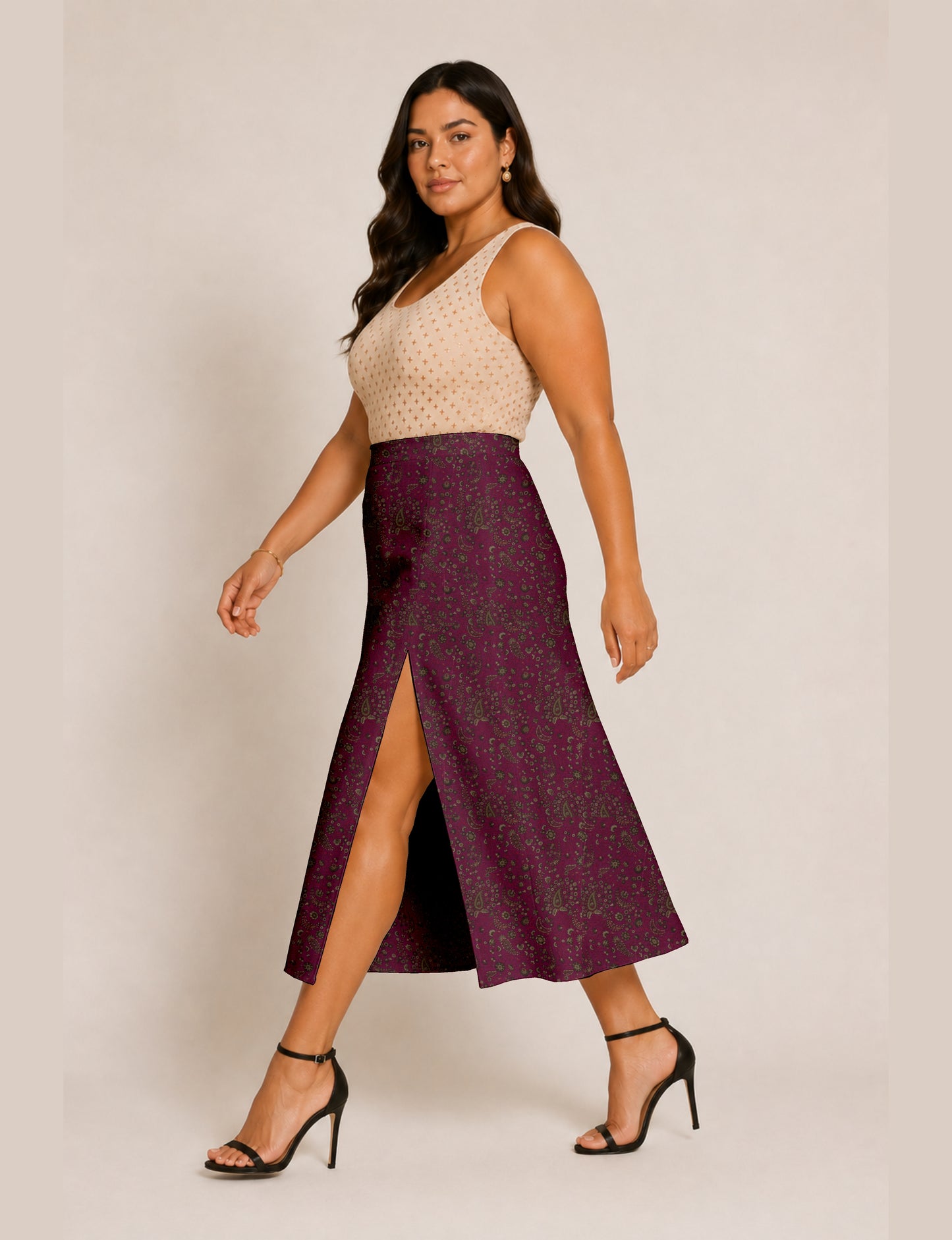 Woman wearing a yellow and black micro patterned A-line skirt with front slit, paired with beige sleeveless top and black
