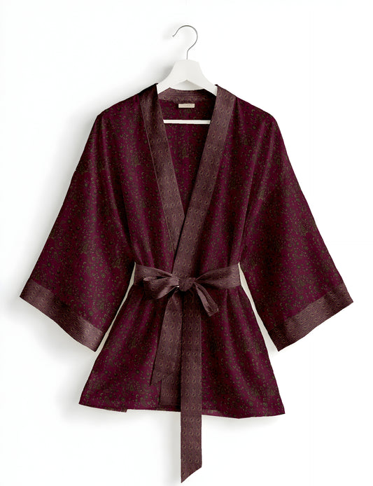 Short kimono robe with wrap front, V-neckline, wide sleeves, waist tie, and concealed skort detail.