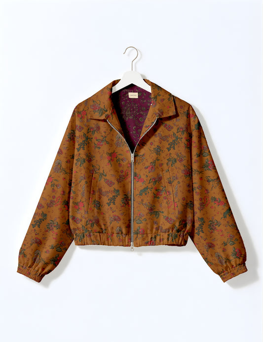 Yellow bomber jacket with micro geometric pattern, silver front zipper, elastic cuffs, and blue floral inner lining, hanging