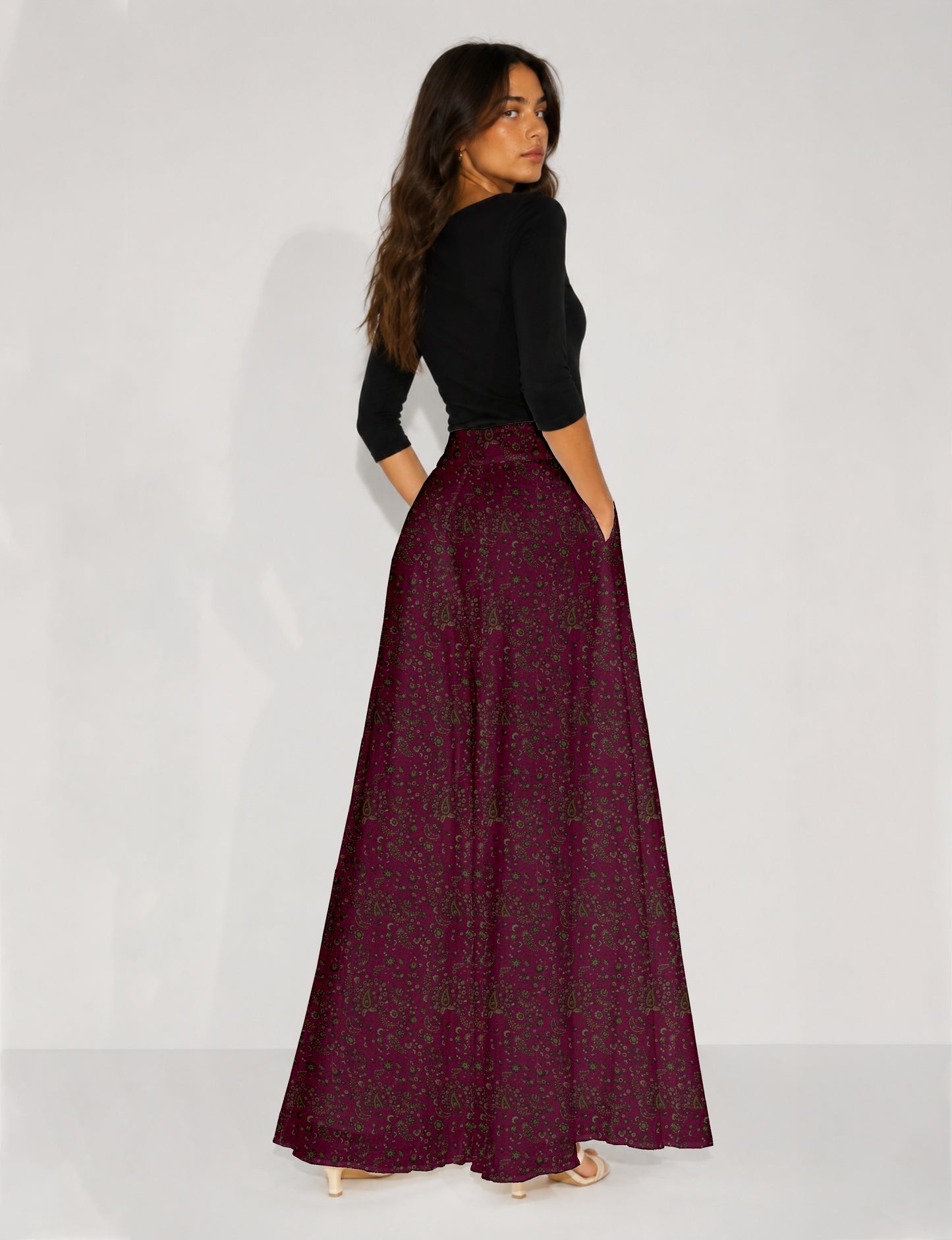 Woman wearing blue wide leg palazzo trousers with black and brown floral print, paired with brown sleeveless top and white