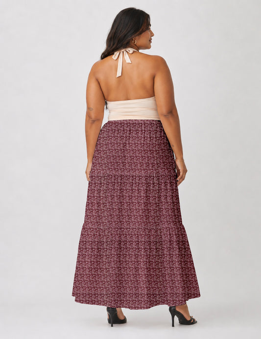 Woman wearing a yellow midi tiered skirt with a small geometric pattern, paired with a beige strapless top and white heels