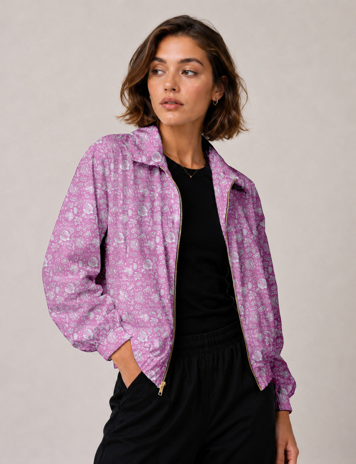 Woman wearing a yellow floral bomber jacket with front zipper, elastic cuffs, and side pockets, shown from front view