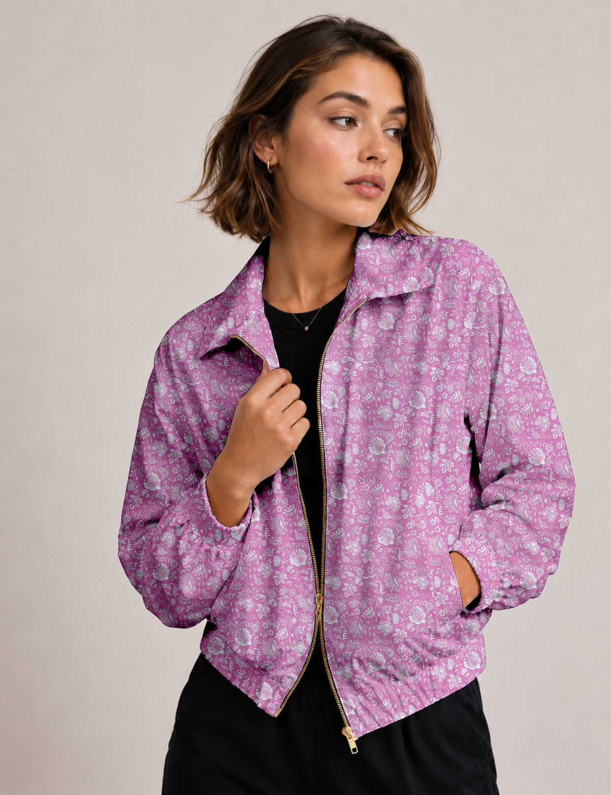 Brown floral bomber jacket with front zipper, elastic cuffs and hem, hanging on white hanger, red floral inner lining visible