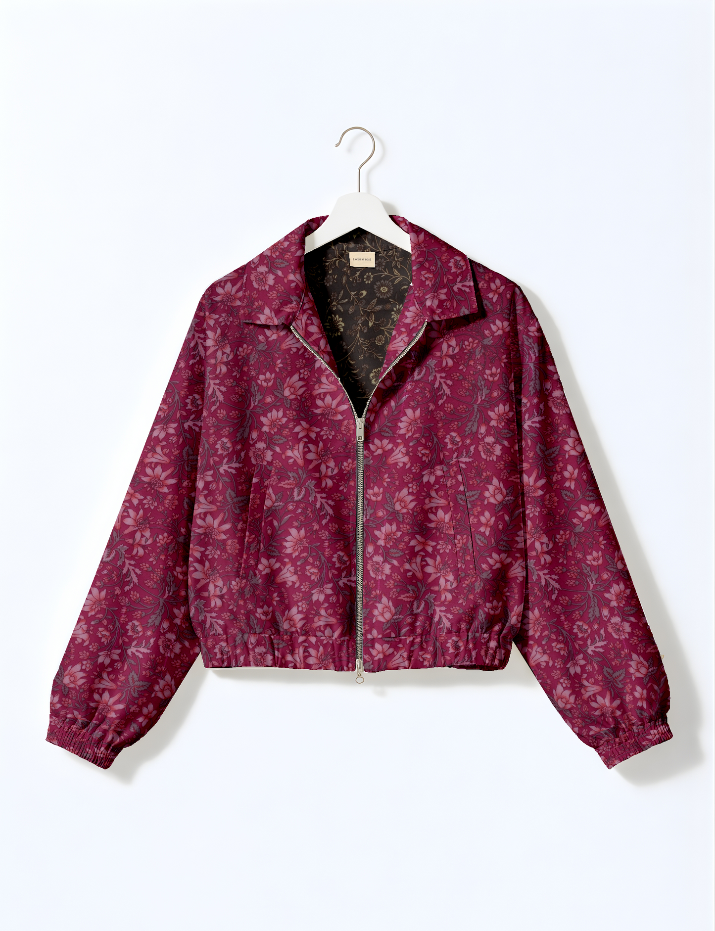 Women's cropped bomber jacket with twin metallic front zippers, welt pockets, elasticated hem and cuffs, and contrast sari print lining.
