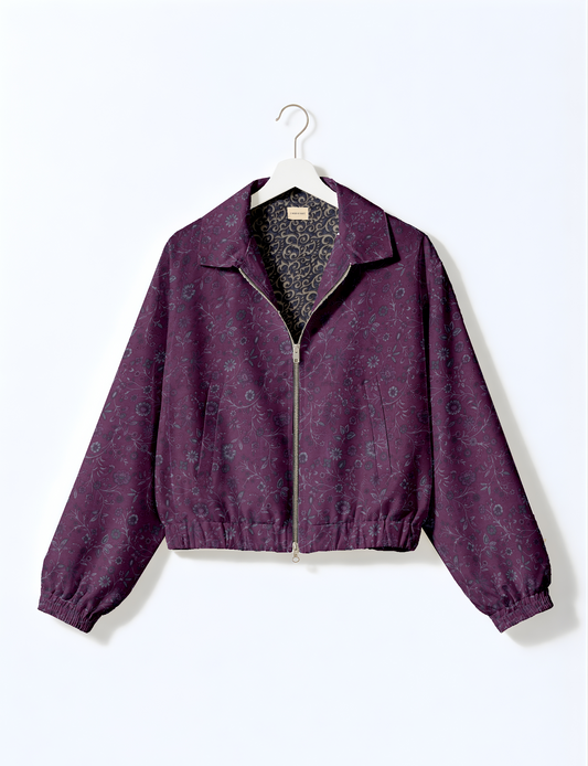 Women's cropped bomber jacket with twin metallic front zippers, welt pockets, elasticated hem and cuffs, and contrast sari print lining.