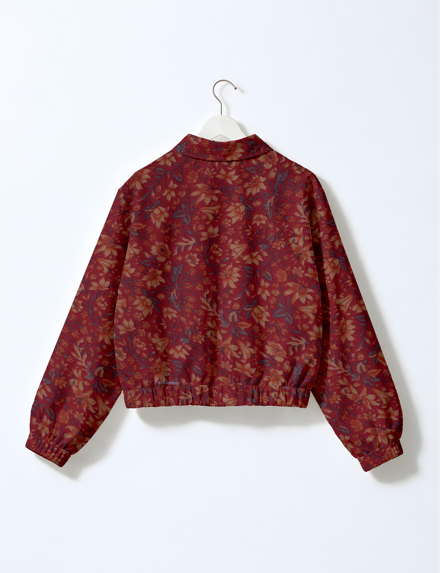 Women's cropped bomber jacket with twin metallic front zippers, welt pockets, elasticated hem and cuffs, and contrast sari print lining.