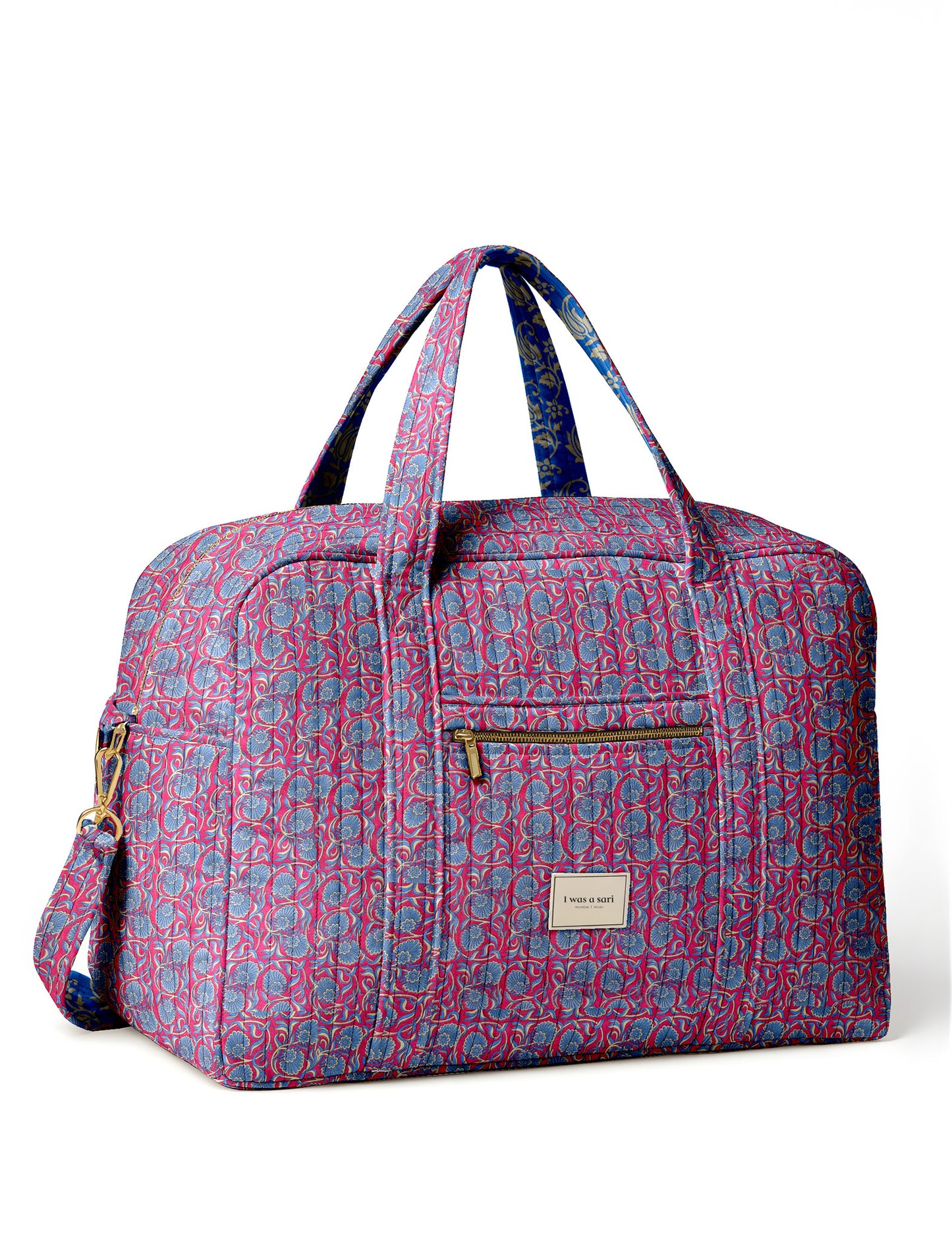 Brown quilted duffle bag with paisley pattern, front zip pocket, dual handles, and label reading "I was a sari"