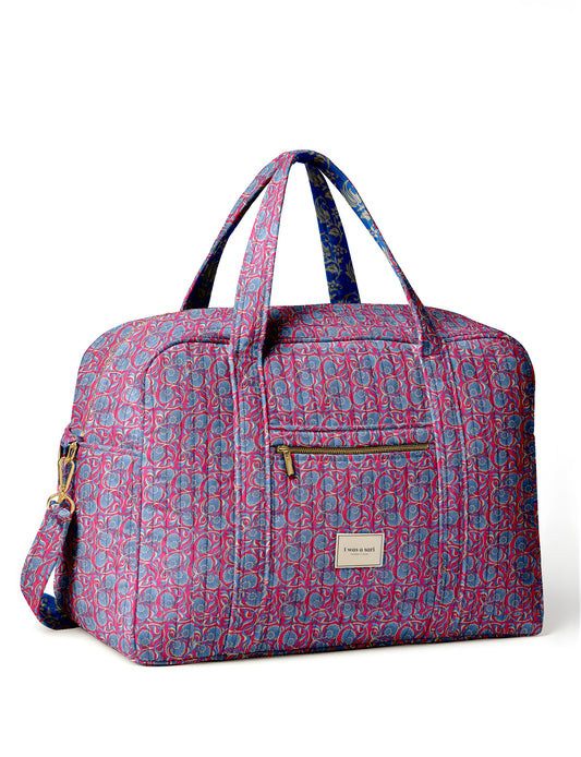 Brown quilted duffle bag with paisley pattern, front zip pocket, dual handles, and label reading "I was a sari"