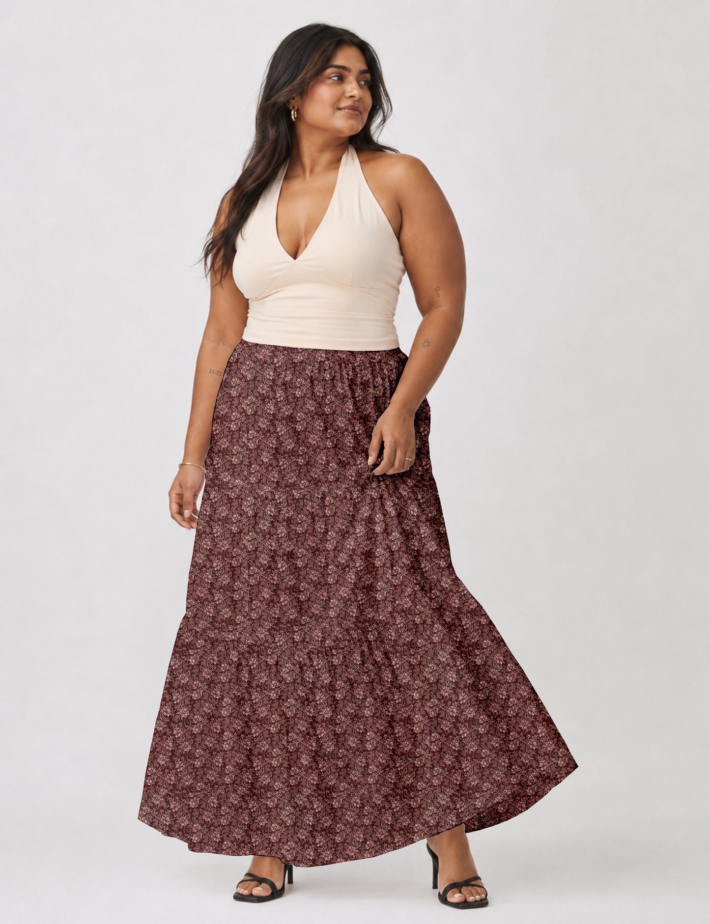 Woman wearing a yellow midi tiered skirt with a small geometric pattern, paired with a beige strapless top and white heels