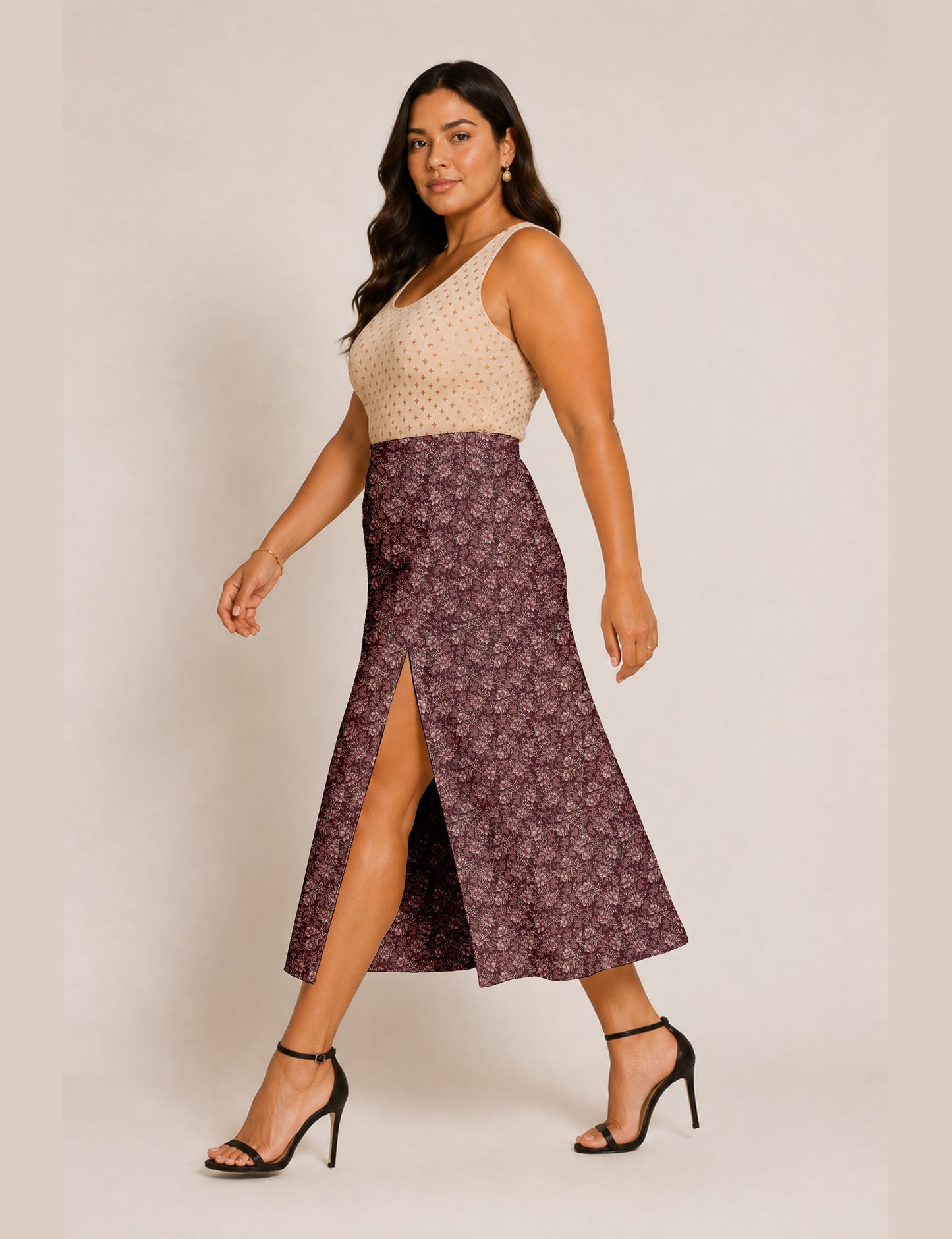 Woman wearing a yellow and black micro patterned A-line skirt with front slit, paired with beige sleeveless top and black