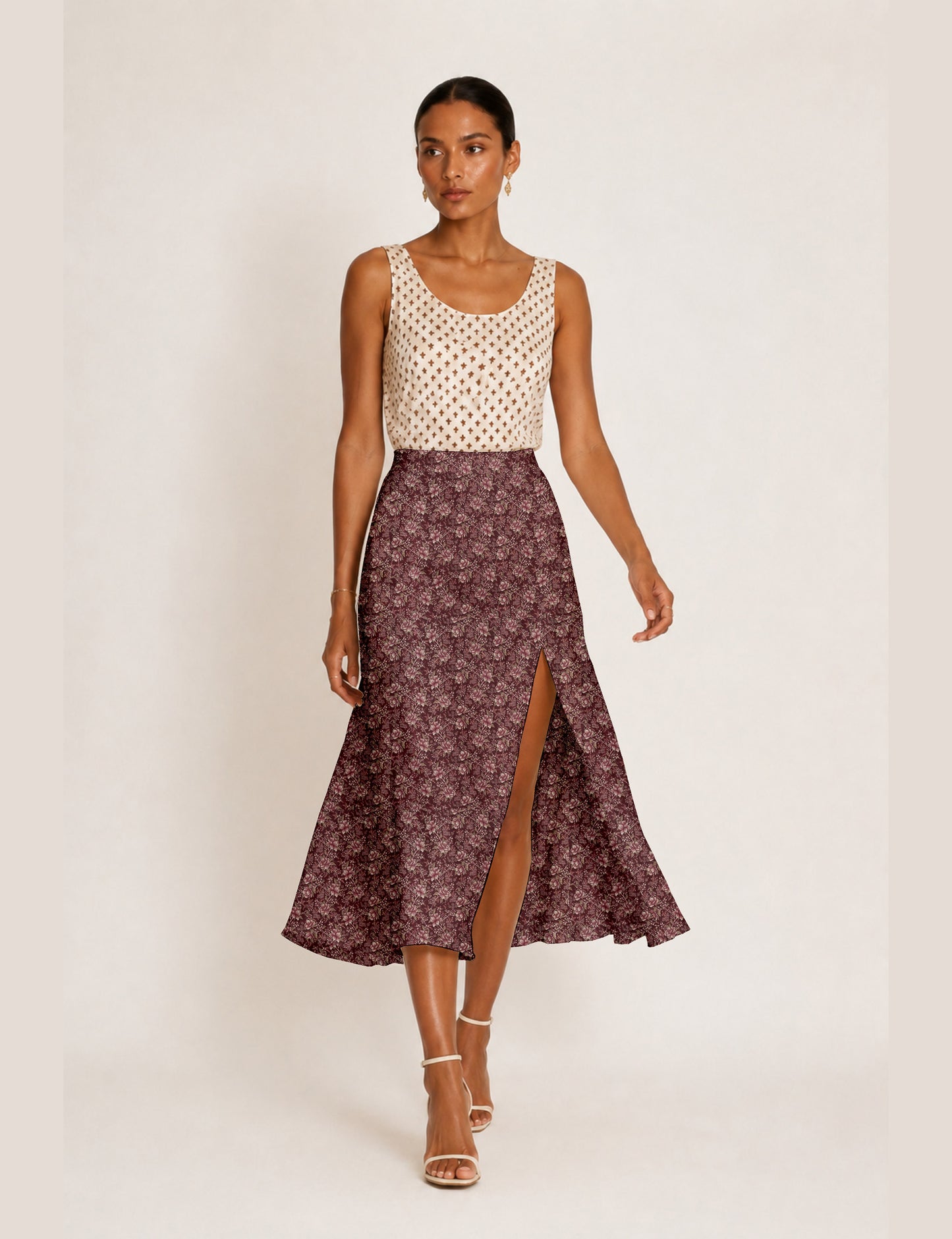 Woman wearing a yellow and black micro patterned A-line skirt with front slit, paired with beige sleeveless top and black
