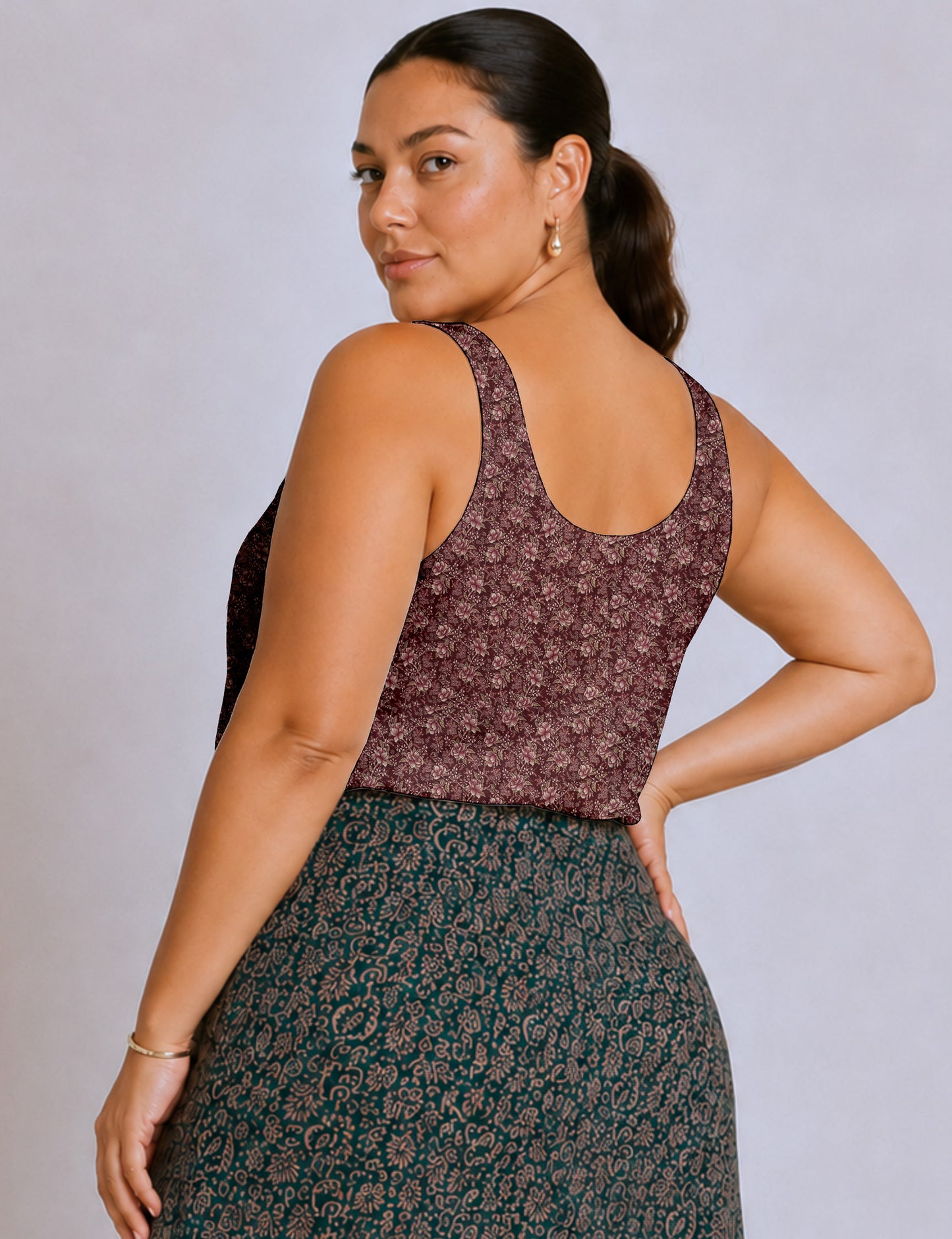 Women's sleeveless blouse with a relaxed straight fit, wide scoop neckline, deep scoop back, and hip-length silhouette.