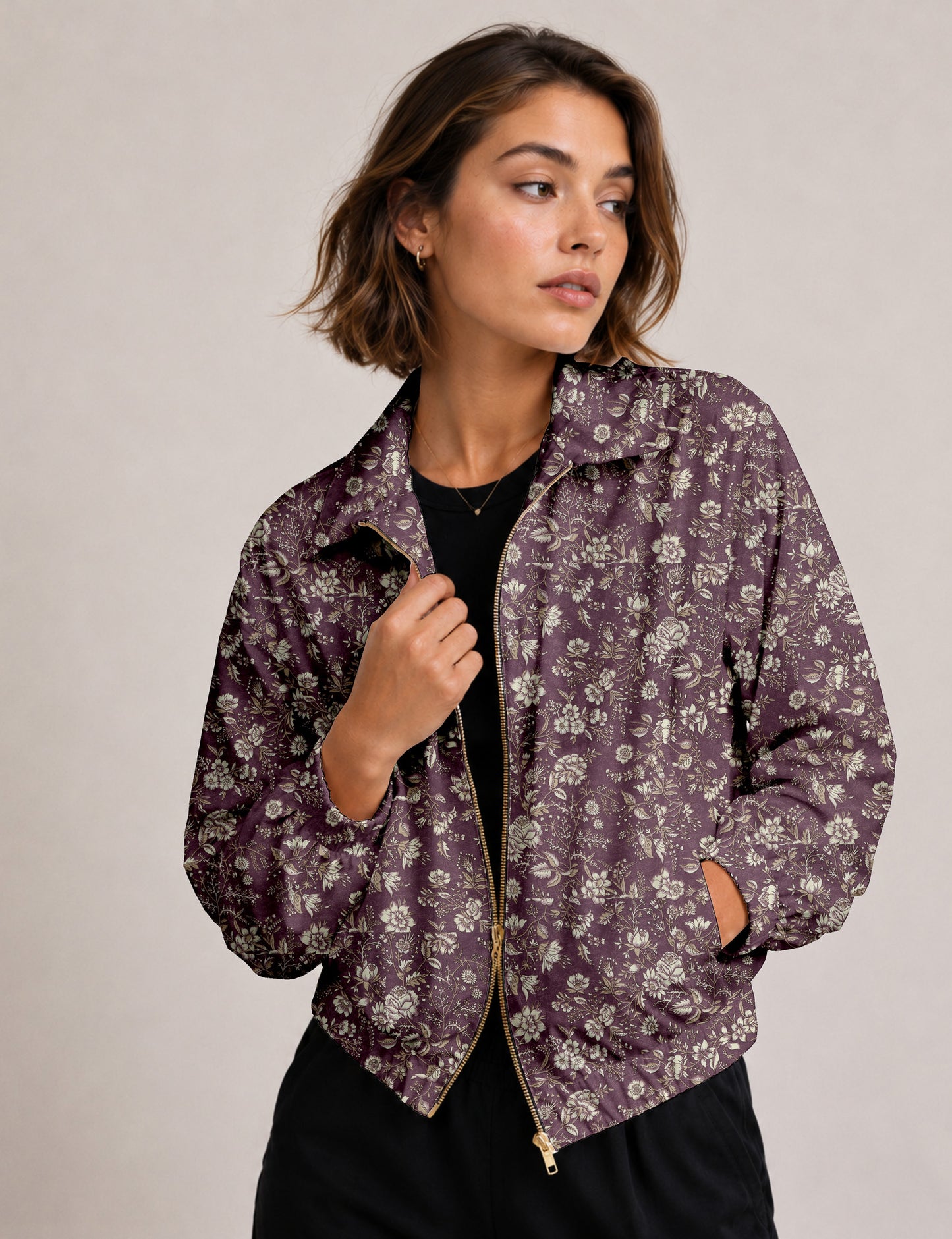 Brown floral bomber jacket with front zipper, elastic cuffs and hem, hanging on white hanger, red floral inner lining visible