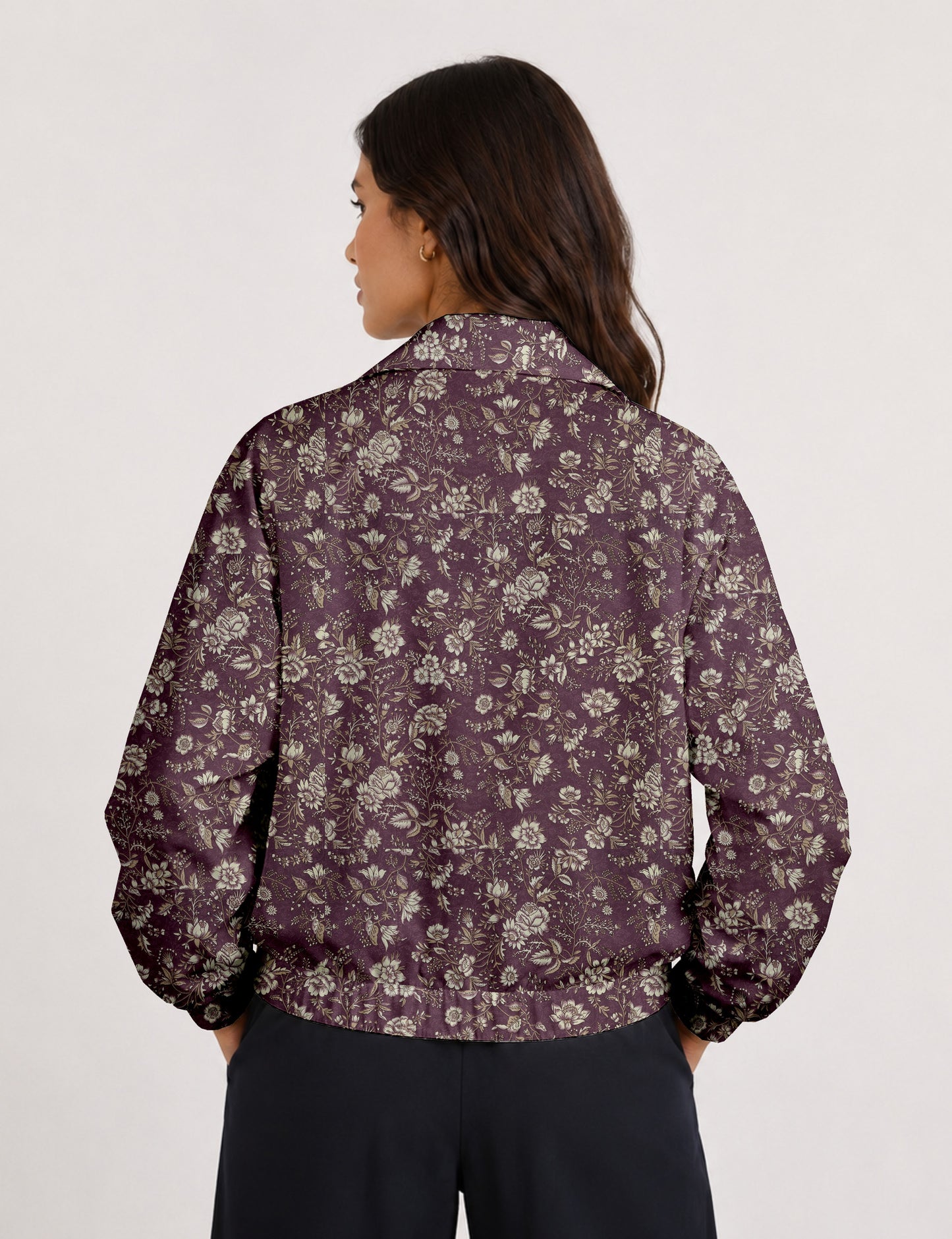 Woman wearing a yellow floral bomber jacket with front zipper, elastic cuffs, and side pockets, shown from front view