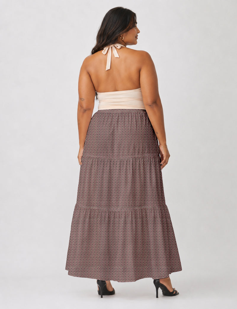 Woman wearing a pink floral midi tiered skirt and beige halter top, shown from back with black heeled sandals