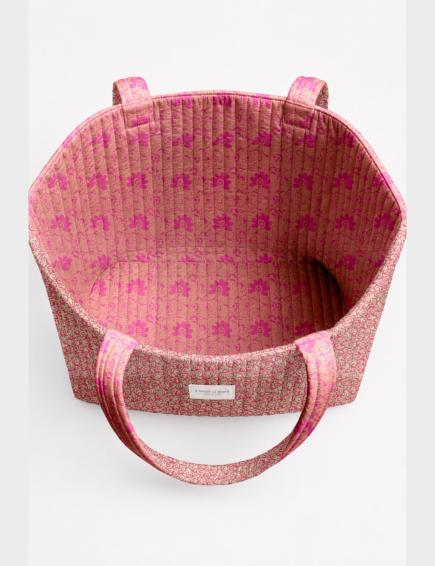 Quilted beach bag with yellow tropical exterior and red patterned interior, shown from top view with handles visible