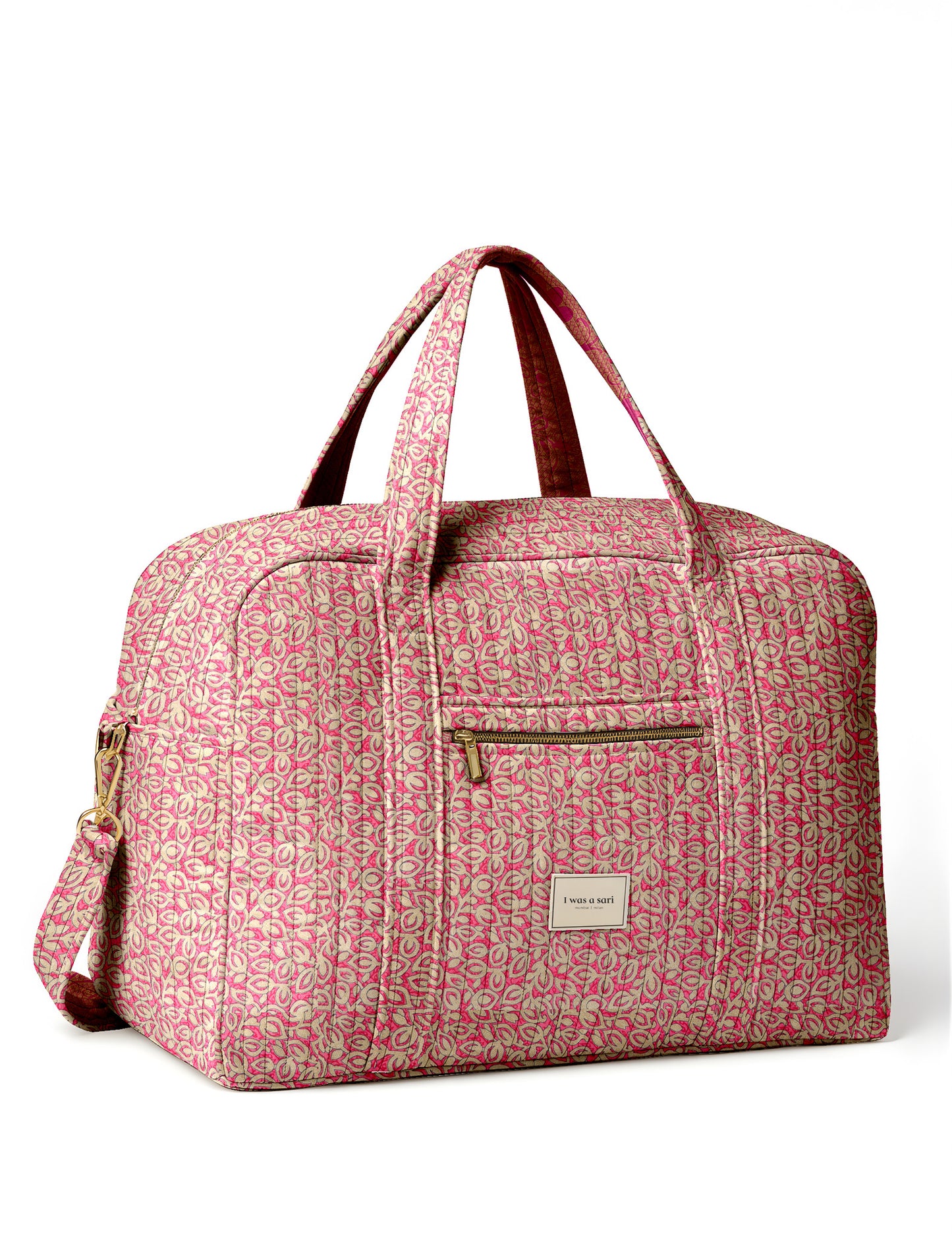 Brown quilted duffle bag with paisley pattern, front zip pocket, dual handles, and label reading "I was a sari"