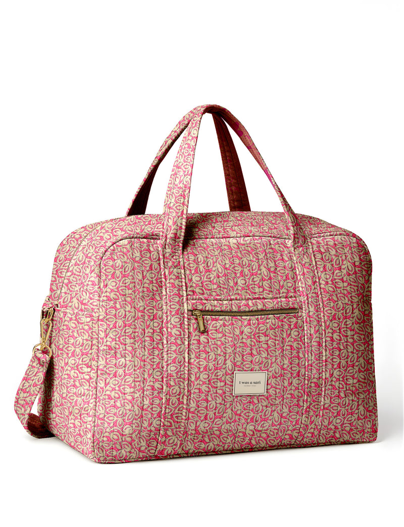 Brown quilted duffle bag with paisley pattern, front zip pocket, dual handles, and label reading "I was a sari"