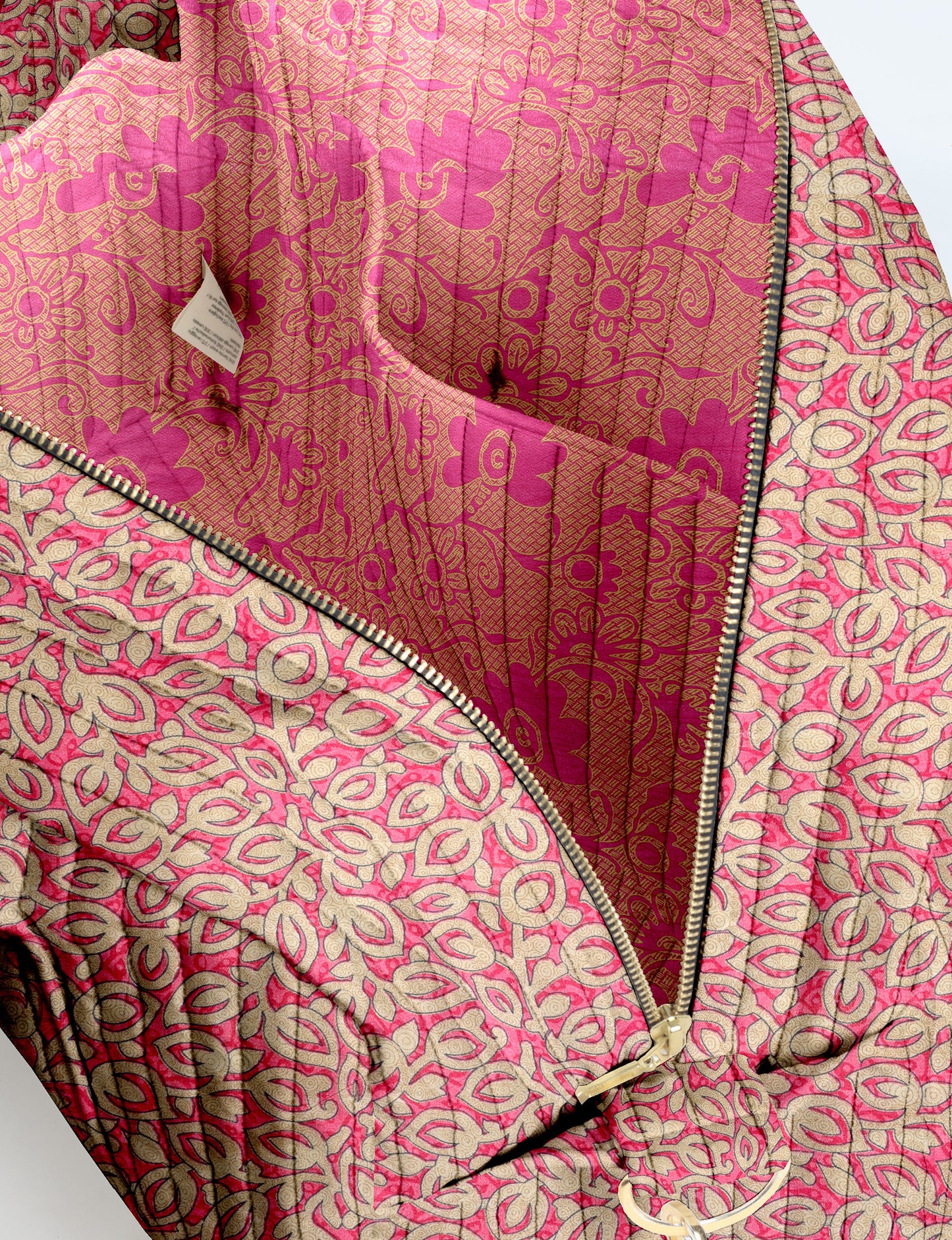 Brown quilted duffle bag with paisley pattern, front zip pocket, dual handles, and label reading "I was a sari"