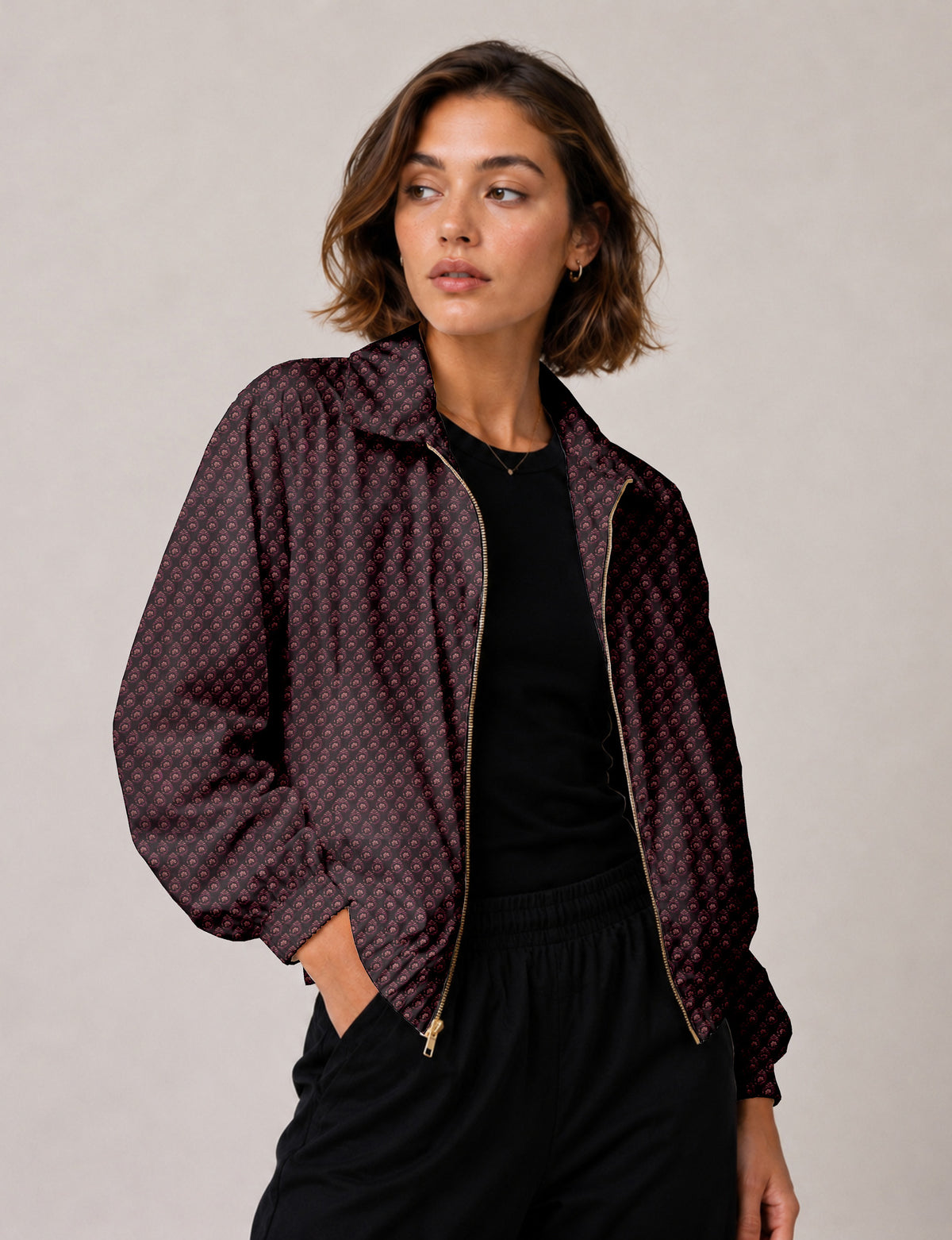 Woman wearing a yellow floral bomber jacket with front zipper, elastic cuffs, and side pockets, shown from front view