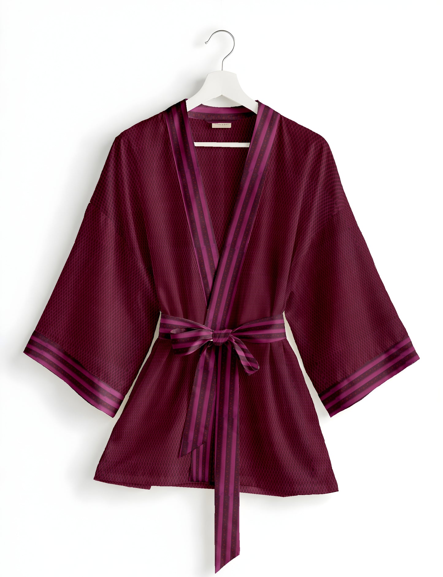 Short kimono robe with wrap front, V-neckline, wide sleeves, waist tie, and concealed skort detail.