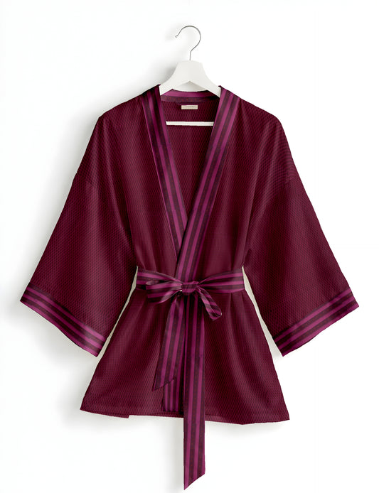 Short kimono robe with wrap front, V-neckline, wide sleeves, waist tie, and concealed skort detail.