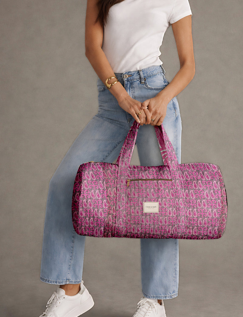 Brown paisley quilted bowling bag with dual handles, front zipper pocket, and "I was a sari" label on front side