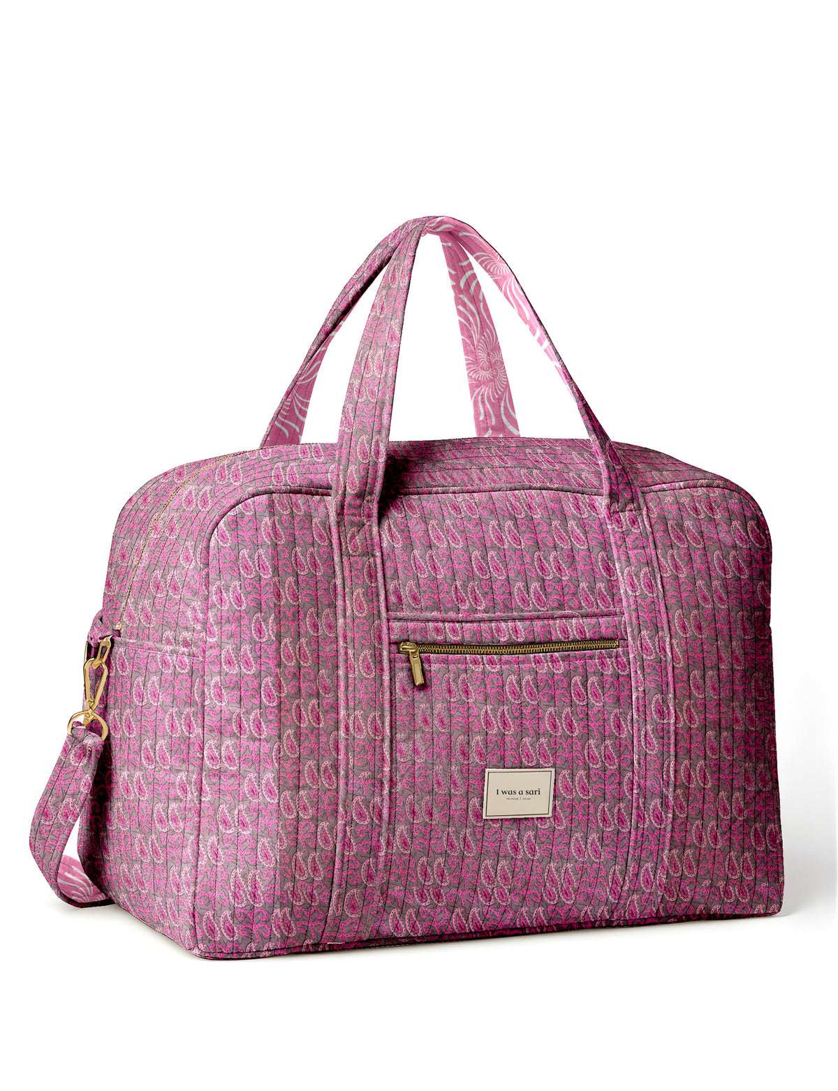 Brown quilted duffle bag with paisley pattern, front zip pocket, dual handles, and label reading "I was a sari"