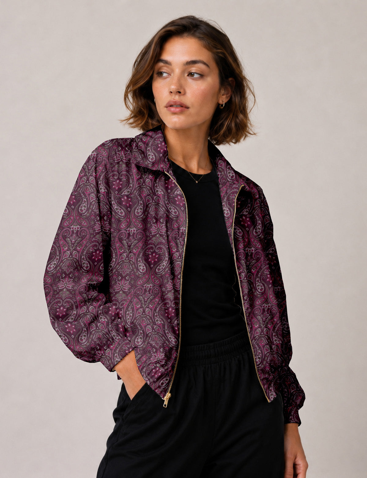 Brown floral bomber jacket with front zipper, elastic cuffs and hem, hanging on white hanger, red floral inner lining visible