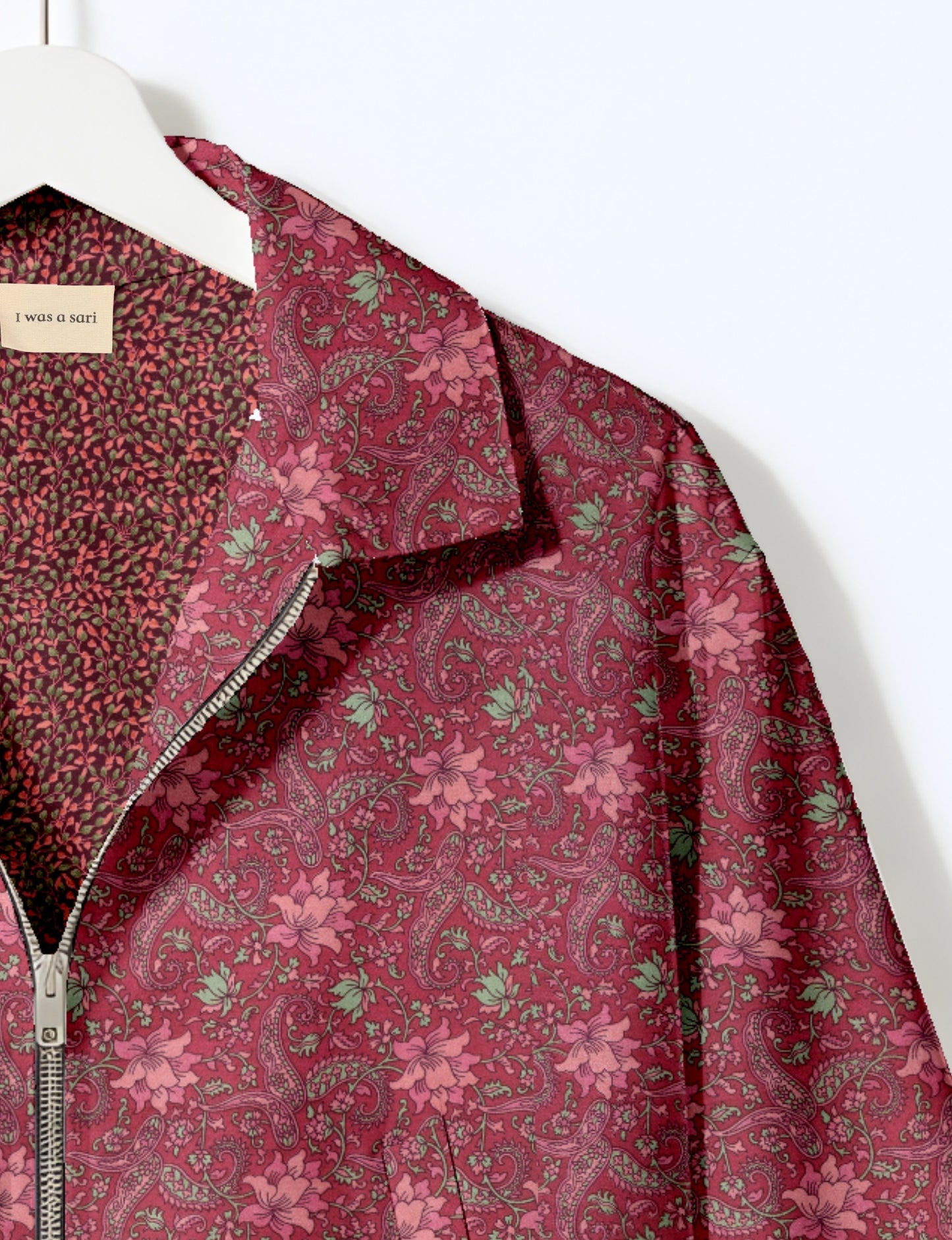 Women's cropped bomber jacket with twin metallic front zippers, welt pockets, elasticated hem and cuffs, and contrast sari print lining.