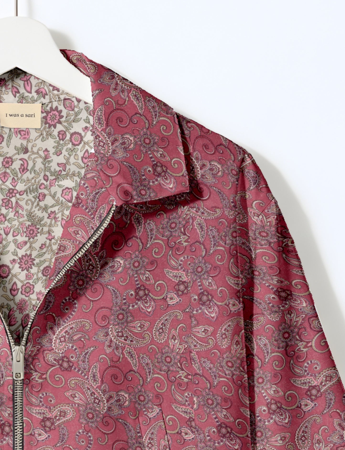 Women's cropped bomber jacket with twin metallic front zippers, welt pockets, elasticated hem and cuffs, and contrast sari print lining.