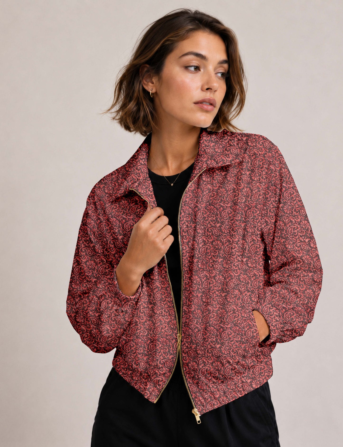Brown floral bomber jacket with front zipper, elastic cuffs and hem, hanging on white hanger, red floral inner lining visible