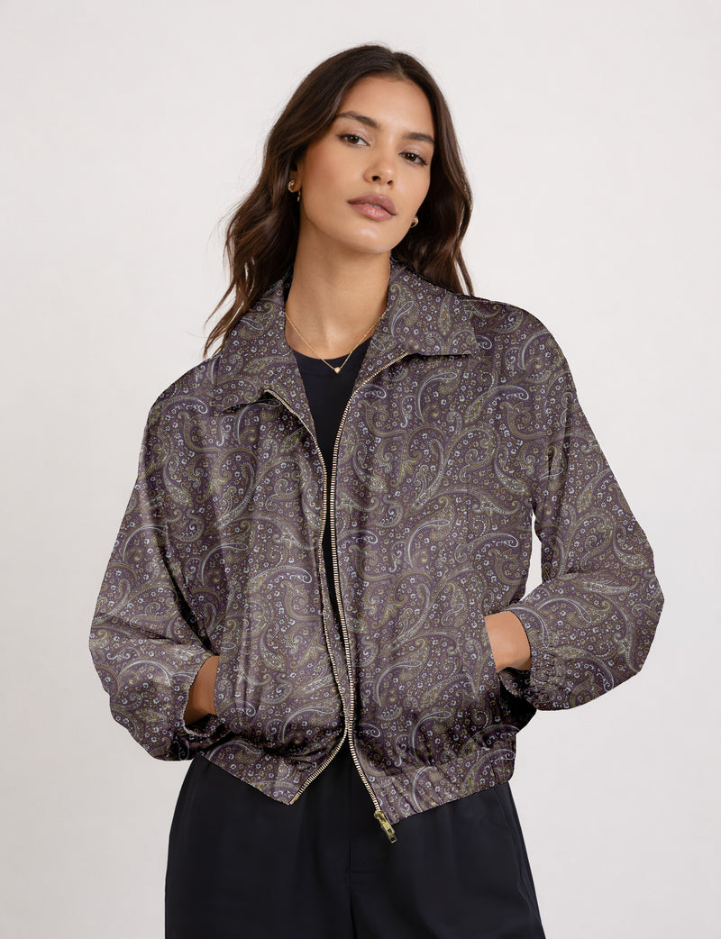 Brown floral bomber jacket with front zipper, elastic cuffs and hem, hanging on white hanger, red floral inner lining visible