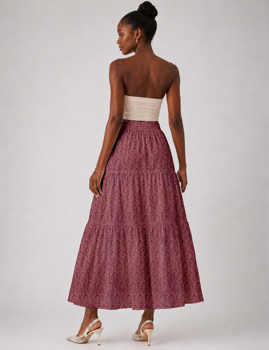 Woman wearing a yellow midi tiered skirt with a small geometric pattern, paired with a beige strapless top and white heels