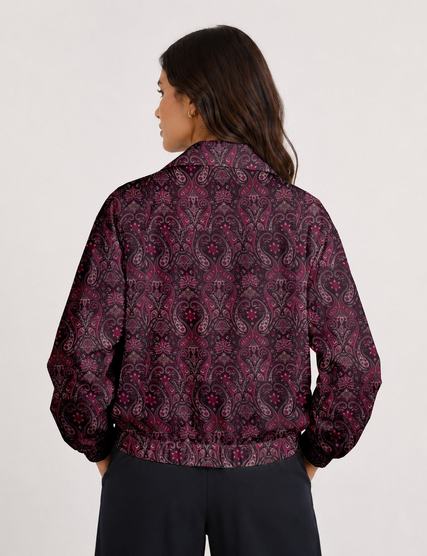 Brown floral bomber jacket with front zipper, elastic cuffs and hem, hanging on white hanger, red floral inner lining visible
