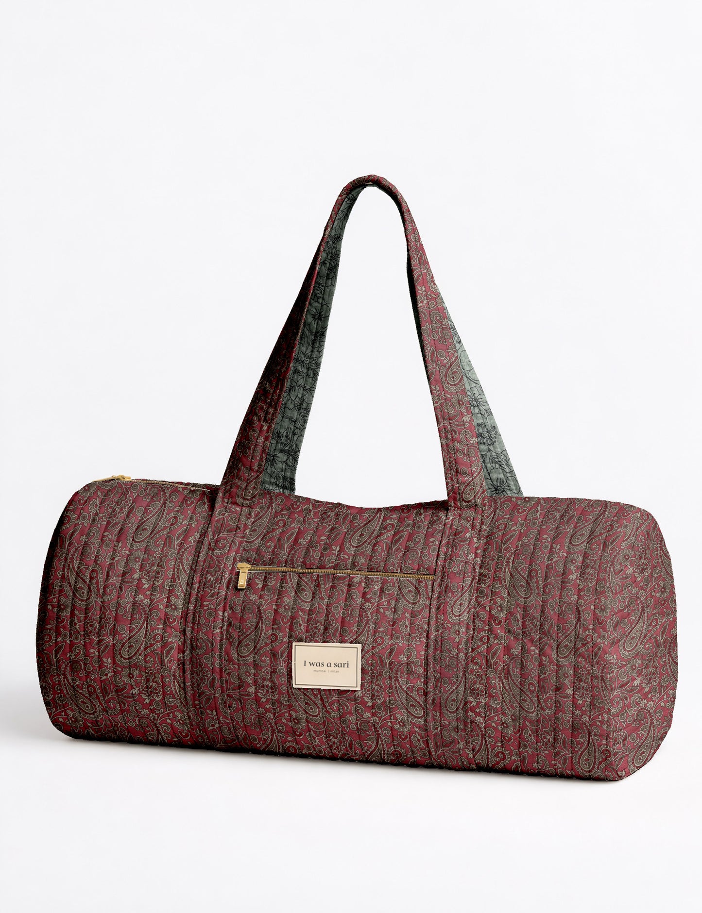 Brown paisley quilted bowling bag with dual handles, front zipper pocket, and "I was a sari" label on front side