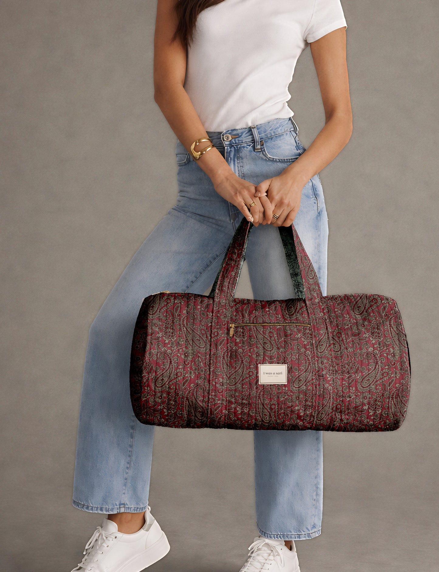 Brown paisley quilted bowling bag with dual handles, front zipper pocket, and "I was a sari" label on front side