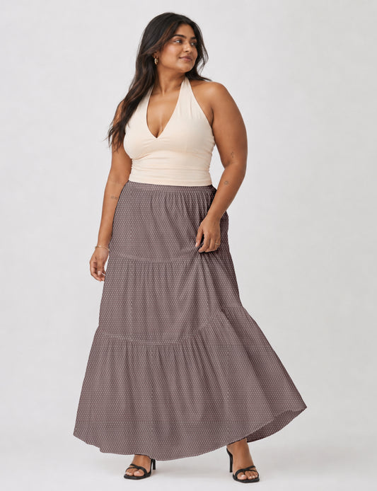 Midi tiered skirt with fitted waistband, soft knife pleats, flared silhouette, side seam pockets, and ankle-length hem