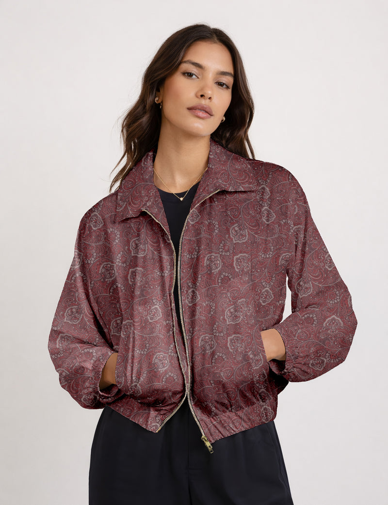 Woman wearing a yellow floral bomber jacket with front zipper, elastic cuffs, and side pockets, shown from front view