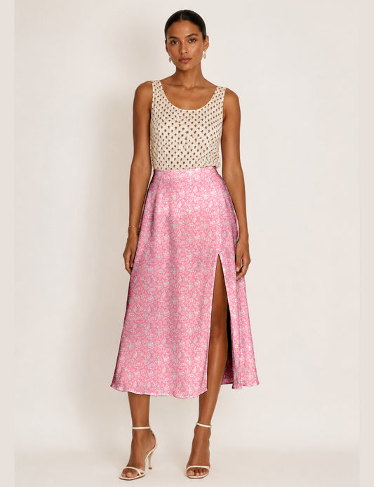 Woman wearing a yellow and black micro patterned A-line skirt with front slit, paired with beige sleeveless top and black