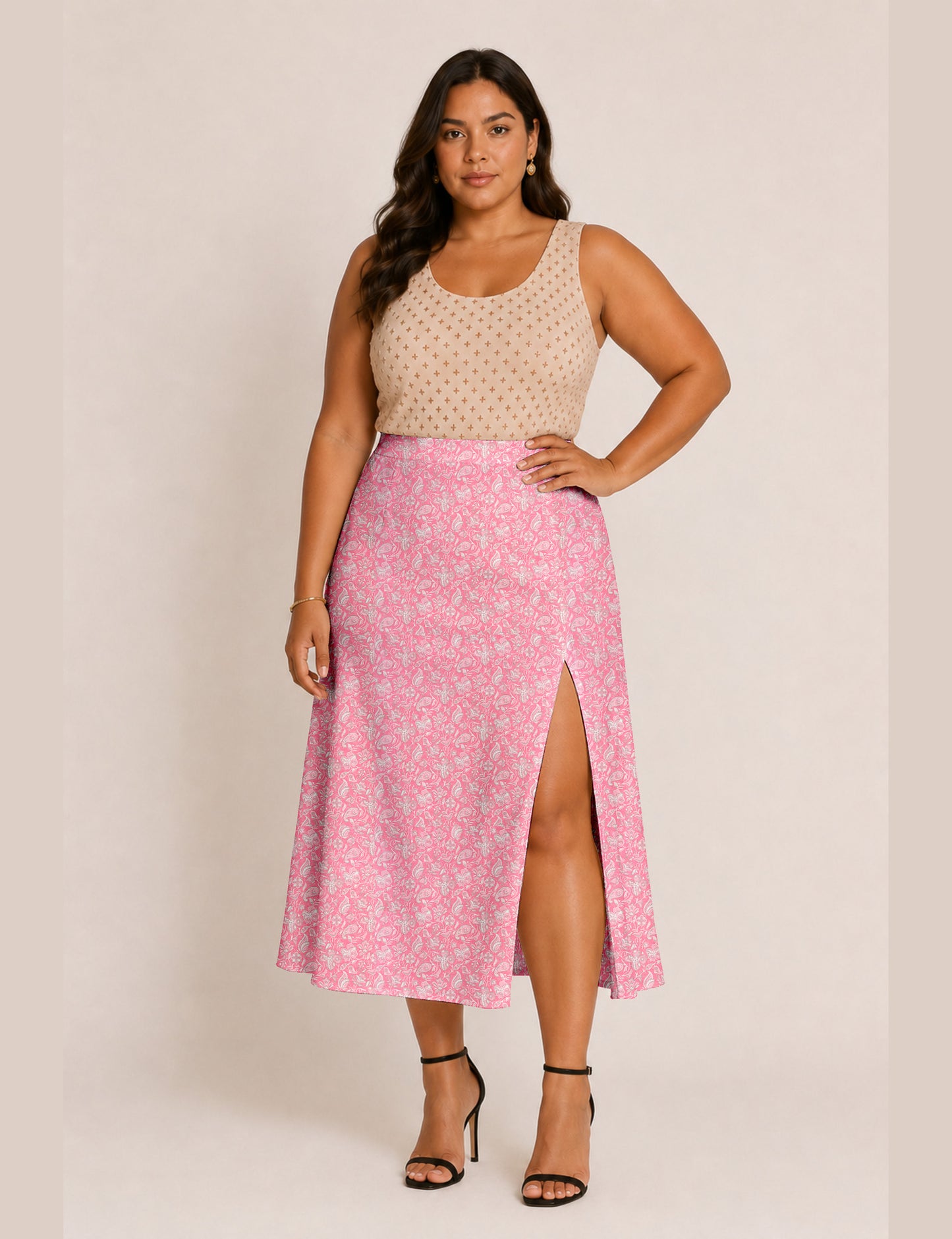 Woman wearing a yellow and black micro patterned A-line skirt with front slit, paired with beige sleeveless top and black