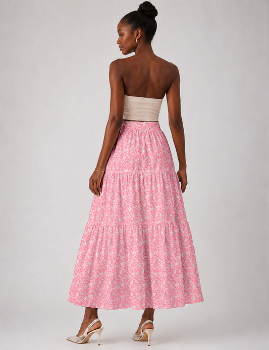 Woman wearing a yellow midi tiered skirt with a small geometric pattern, paired with a beige strapless top and white heels
