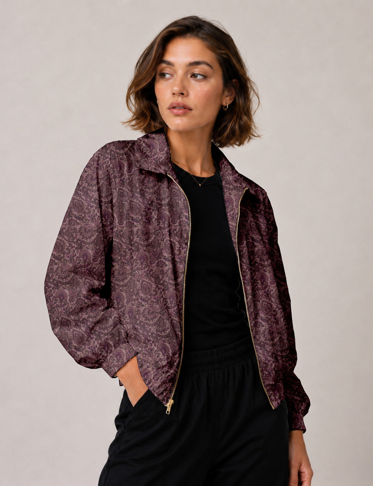 Brown floral bomber jacket with front zipper, elastic cuffs and hem, hanging on white hanger, red floral inner lining visible