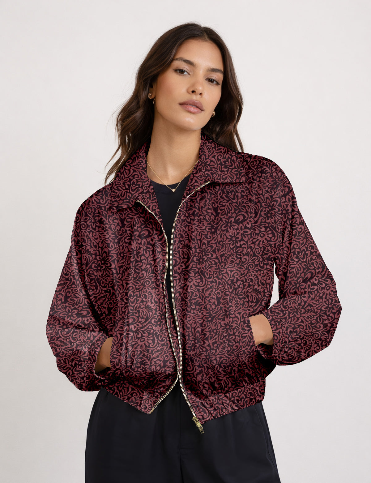 Woman wearing a yellow floral bomber jacket with front zipper, elastic cuffs, and side pockets, shown from front view