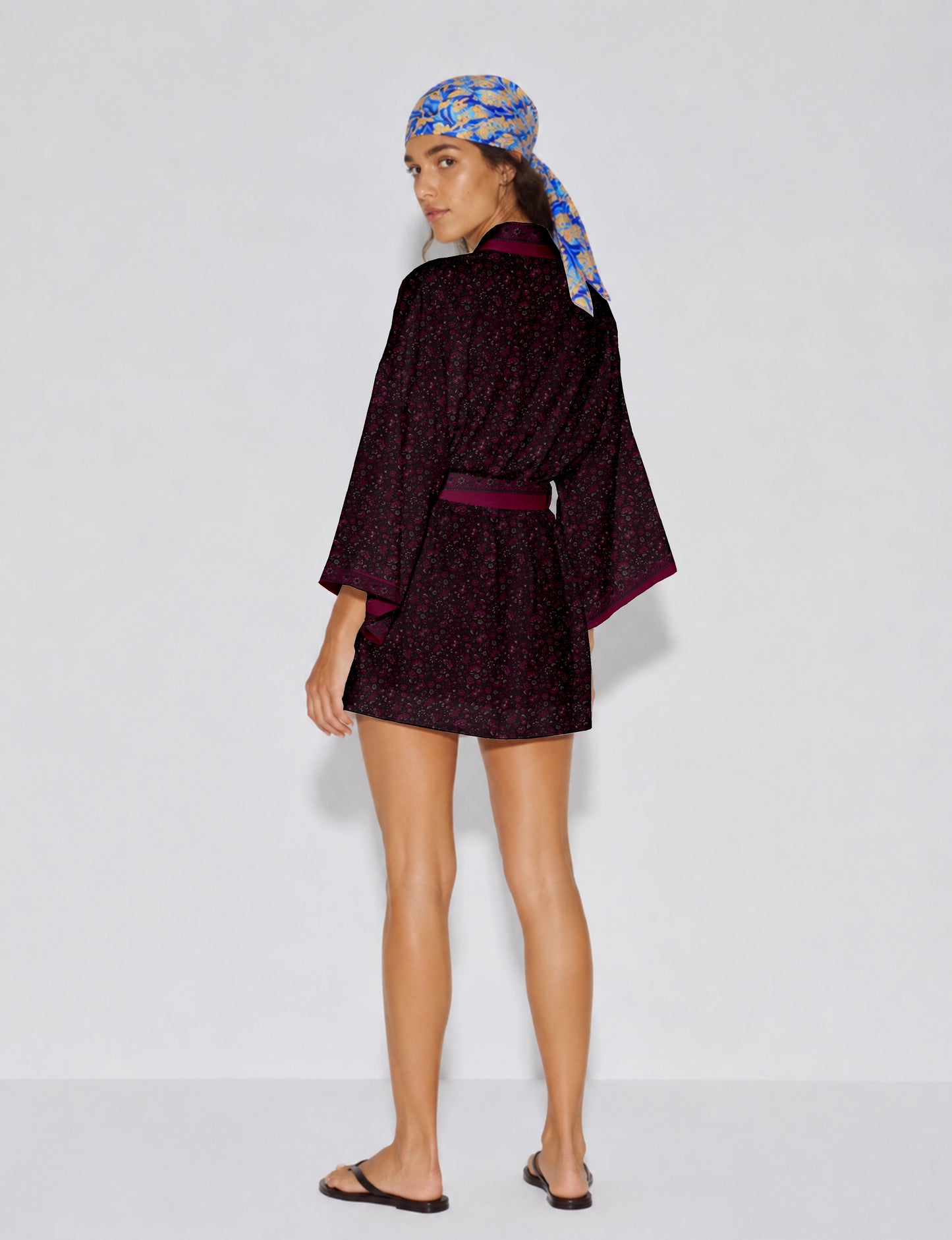 Short kimono robe with wrap front, V-neckline, wide sleeves, waist tie, and concealed skort detail.