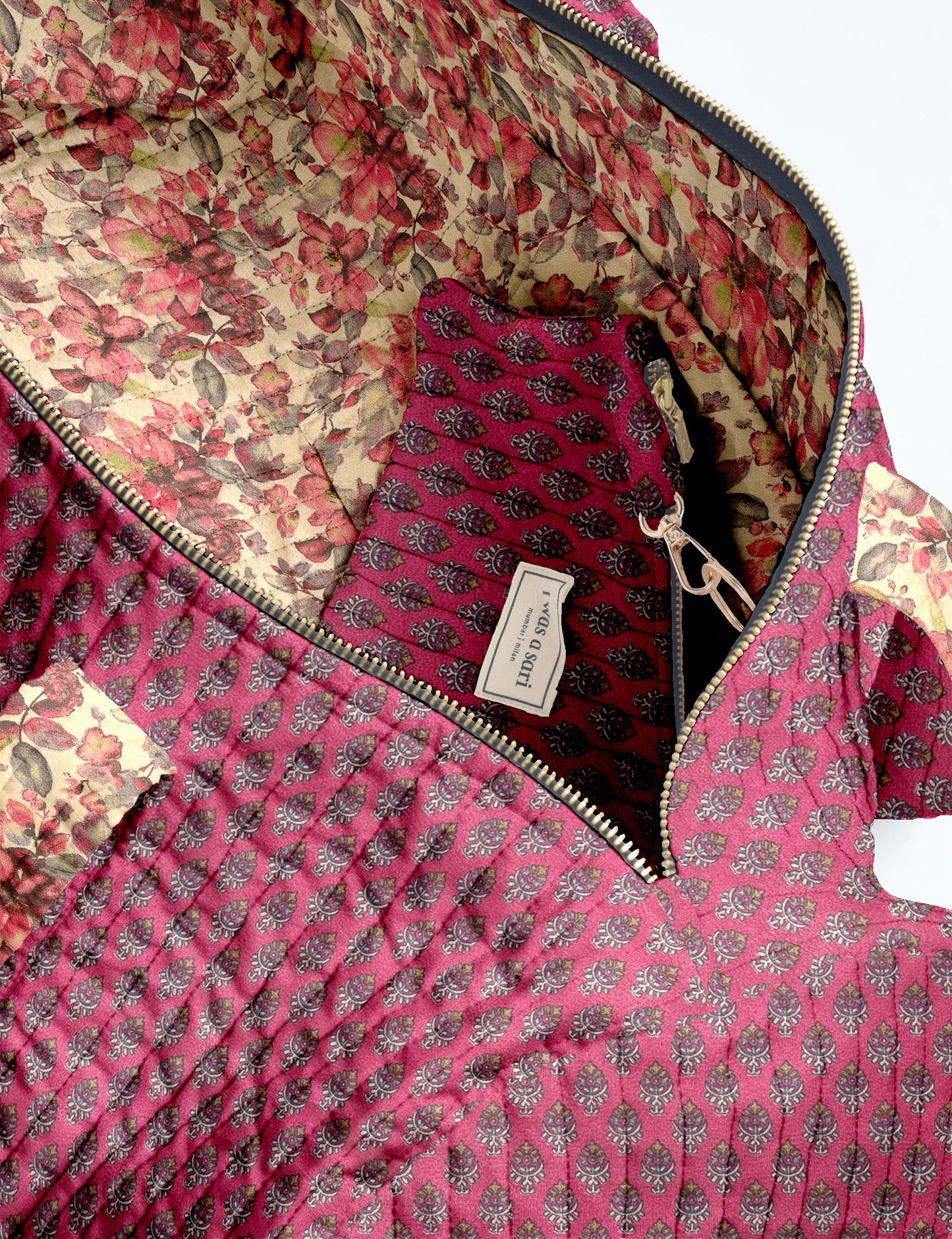 Brown paisley quilted bowling bag with front zipper pocket, held by person wearing white shirt and light blue jeans